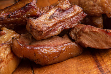 Smoked pork ribs and meat on wooden board