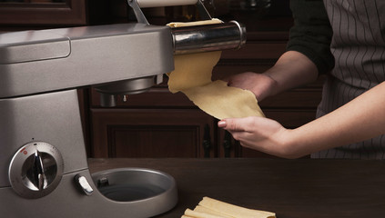 Rolling raw dough with pasta machine