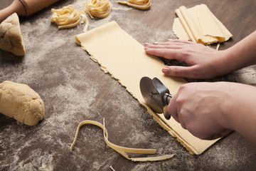 Chef using wheel cutter in preparation of pasta
