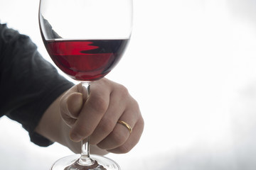 hand holding wineglass with red wine