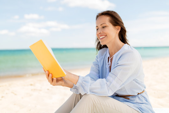 People And Leisure Concept - Happy Smiling Woman Reading Book On Summer Beach