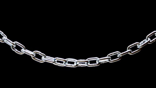 Steel chain hanging on a black background. Chain links close-up.