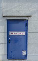 Blue door with sign saying "emergency exit" in german language