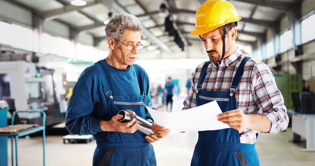 Team Of Engineers Having Discussion In Factory