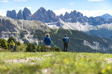 Two hikers walking to the geisler mountains in the italian dolomites