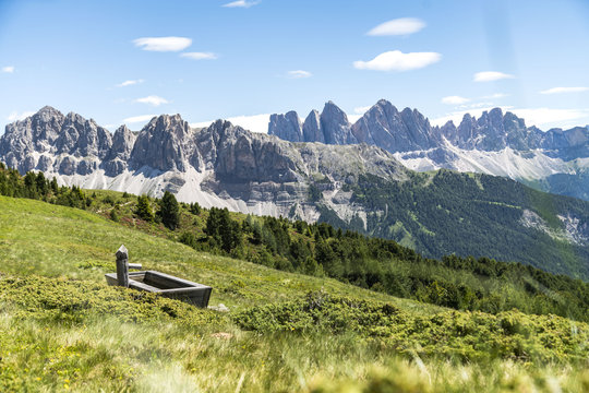Fountain on pasture with a beautiful view on the Geisler alm from the plose (italian dolomites)