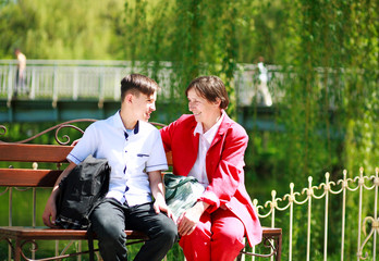 Fototapeta premium Smiling grandmother and grandson relax and talking together in summer park
