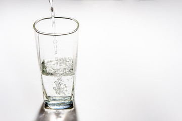 Pour drinking water into the tall glass.