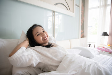 Cheerful woman wake up with fresh feeling in clean bedroom