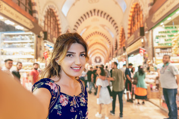 Beautiful woman in a dress takes selfie in Egypt Bazaar