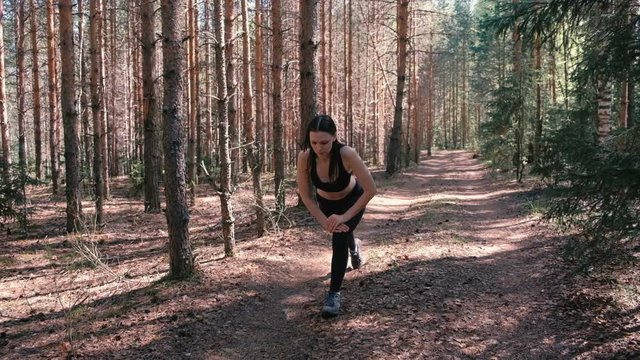 Woman doing sports exercises in the woods. Slow motion.