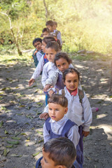 Rural Indian village school children standing outside class for morning prayer.