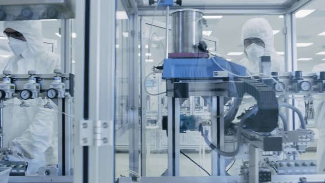 On a Factory Team of Scientists in Sterile Protective Clothing Work on a Modern Industrial 3D Printing Machinery. Pharmaceutical, Biotechnological and Semiconductor Creating / Manufacturing Process.