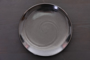 黒い木製テーブルに置かれた黒い皿
