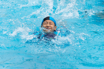 Portrait of a boy playing in public swimming pool
