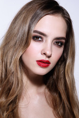 Fototapeta premium Young beautiful girl with long curly hair and red lipstick