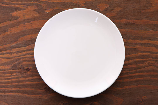 茶色い木製テーブルに置かれた白い皿