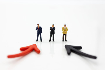 Obraz premium Miniature people: Businessman standing in front of arrow pathway choice. Image use for Business decision concept.