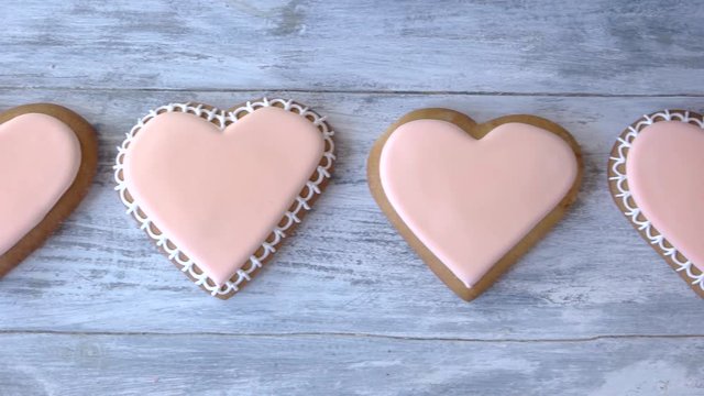 Row of heart shaped biscuits. Delicious decorated cookies on wooden background. Way to express love.