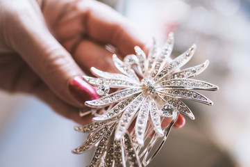 Silver jewelery with diamonds in a woman's hand