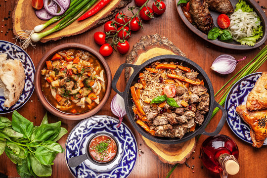 Traditional Uzbek oriental cuisine. Uzbek family table from different dishes for the New Year holiday. The background image is a top view.