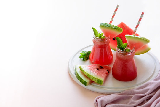 Summer watermelon smoothie decorated mint leaves on pink background. Summer drink concept