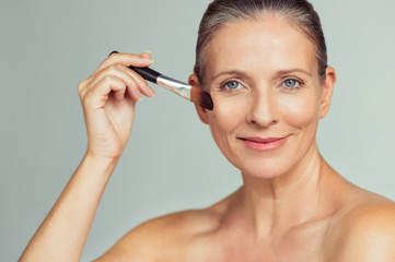 Woman applying make up for perfect skin