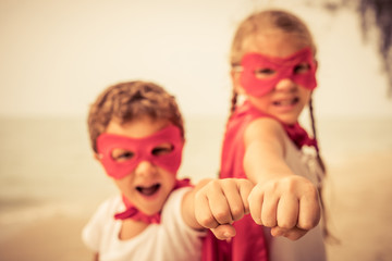 Two happy little children playing on the beach at the day time.