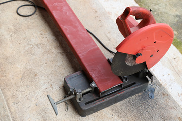Closeup of electric metal cutter on cement floor with outdoor sunlight. 