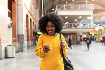 Beautiful woman using mobile in the train station