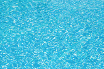 Bright water surface and ripple wave in swimming pool, Blue tile in pool with gentle wave motion and reflection