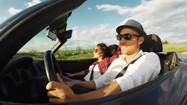 4K footage of a couple going in the convertible and funny smiling
