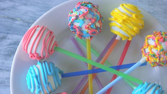 Colorful glazed sweets on sticks. Delicious biscuits with colorful frosting. Baked lollipops for kids party.