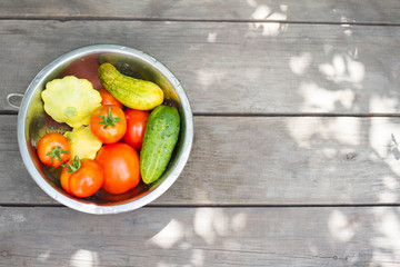 Tomato, cucumber, zucchini, patisson in an iron pan on a wooden table. Concept of a healthy diet, dietetic vegetables. Harvesting