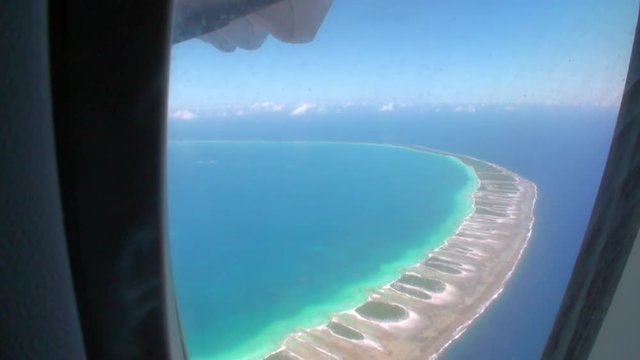 View from window of airplane on ocean coast. Picturesque wild nature of French Polynesia Tahiti Island. Beautiful landscape.