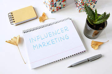 influencer marketing written in a notebook on white table