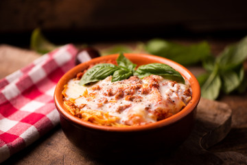 Traditional lasagne in a casserole dish on wooden table