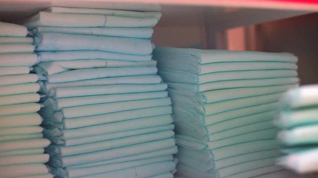 The hand takes a few nappies out of the pile. Disposable towels in quarantine of viral infection COVID 19. Self isolation.