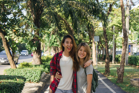 Happy young asian women couple playing to each other while they do city trip in warm sunlight morning weekend. City and nature lifestyle of Young women. Lifestyle in the city activity concept.