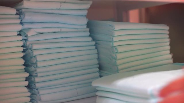 The hand takes a few nappies out of the pile. Disposable towels in quarantine of viral infection. Self isolation.