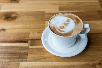 Latte art coffee cup  on wooden table, top view