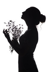 silhouette profile of a beautiful girl with a bouquet of dried flowers on a white isolated background