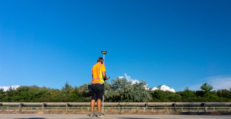 Worker or builder (Surveyor) with GPS on construction site during the sunny day with blue sky in background