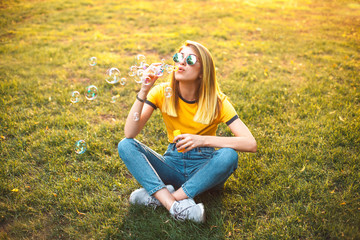 Fototapeta premium Young woman are blowing soap bubbles outdoors