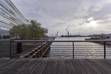  Мост через морской канал в сумерках и вид на промышленный порт в Орхусе. Дания.