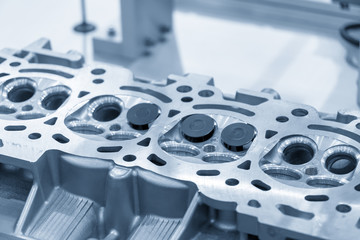 The cylinder head with the valve in the light blue scene.Automotive part manufacturing process .