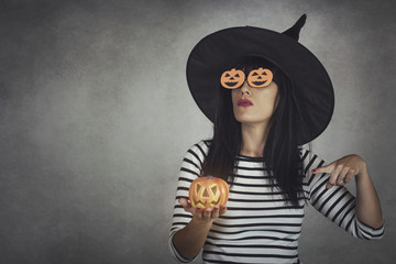 Young woman holding a pumpkin in halloween