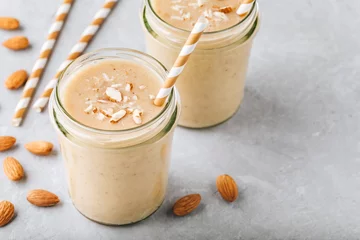 Printed kitchen splashbacks Milkshake Banana almond smoothie with cinnamon and oat flakes and coconut milk in glass jars
