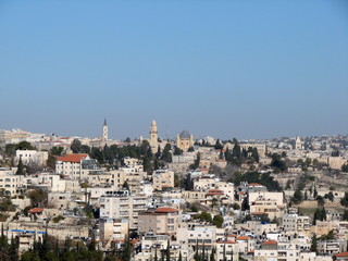 Fototapeta premium Panorama of the streets, buildings and temples of the city of Jerusalem from the height of the bird's eye on the background of a clean blue sky.