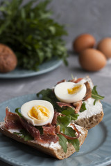 Sandwiches with whole grain bread, homemade cheese, arugula, ham and egg. Healthy snack.
